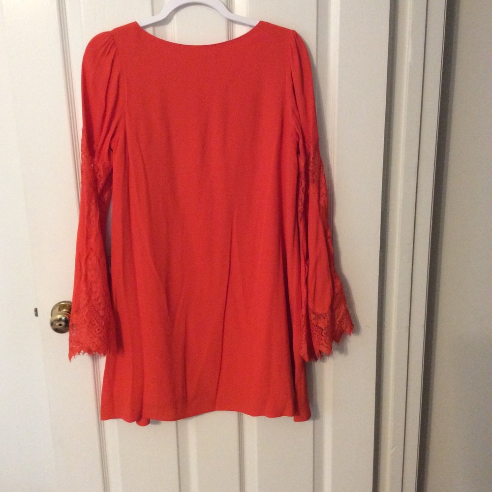 Coral dress with lace sleeves.